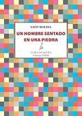 un hombre sentado en una piedra