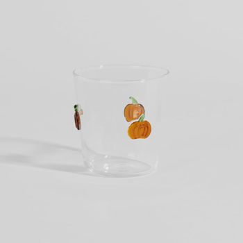 Vaso de vidrio transparente con calabazas naranja