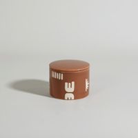 vela perfumada en ceramica marron con tapa aroma chimenea