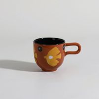 taza de gres marron y amarillo con pajaro