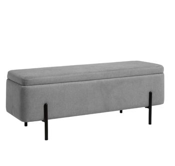 Banqueta baúl tapizada con almacenamiento en gris y patas negras.