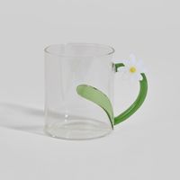 taza de vidrio transparente con asa de flor