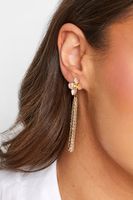 pendientes dorados de flores y borlas